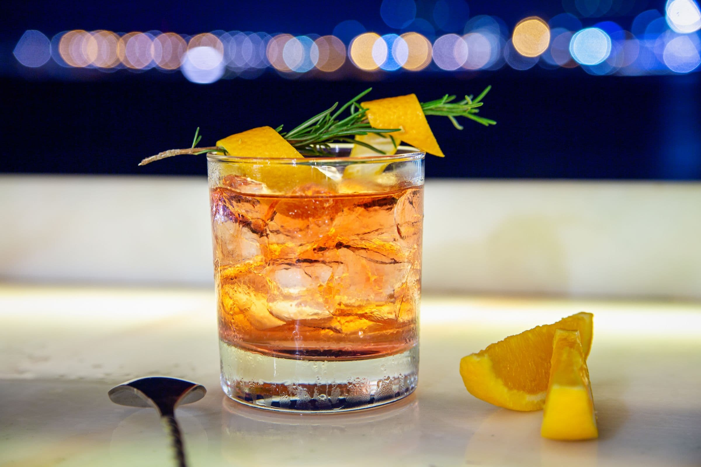 An old fashioned cocktail on a dark bar