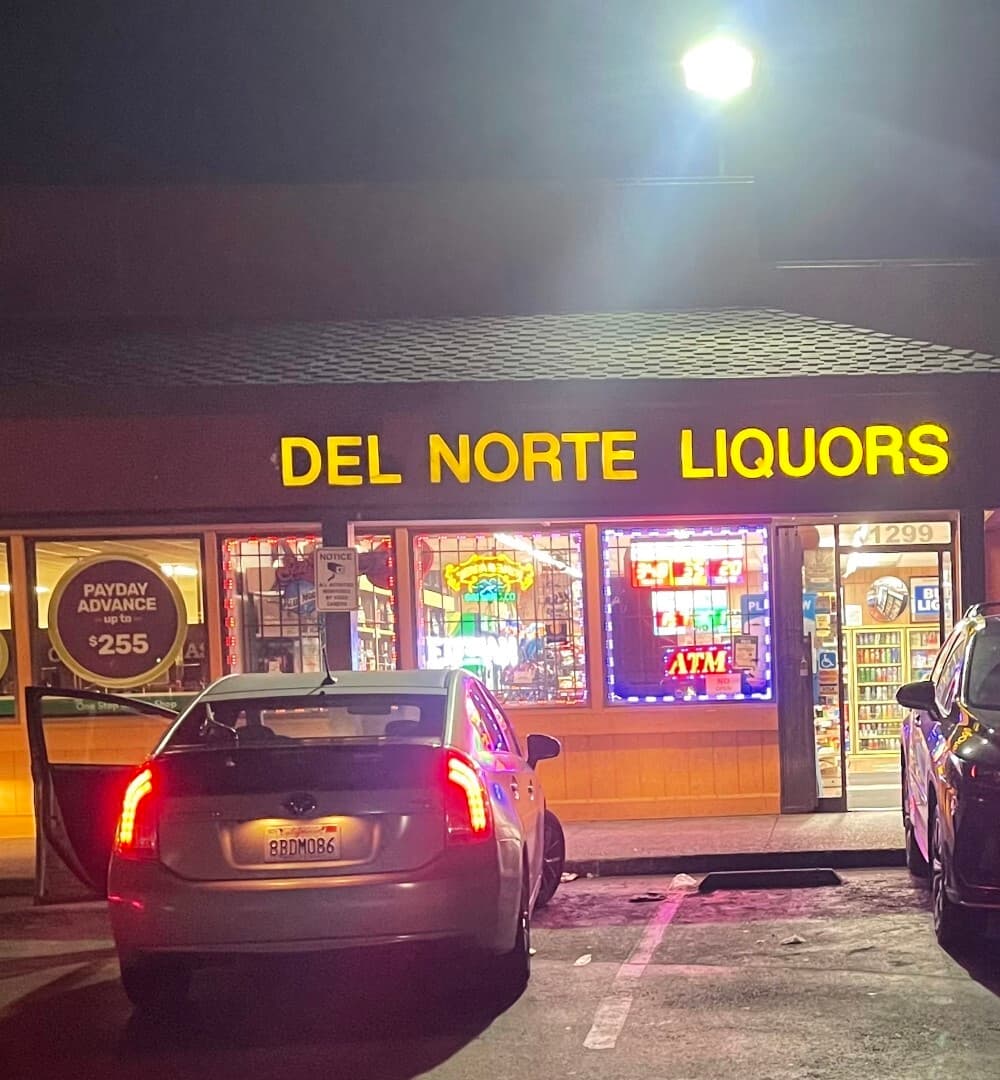 Del Norte Liquors storefront at night in El Cerrito